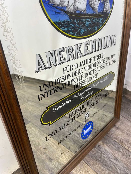Lustro z reklamą w drewnianej ramie