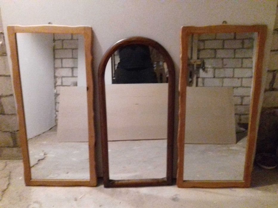 Lustra ścienne w drewnianych ramach.