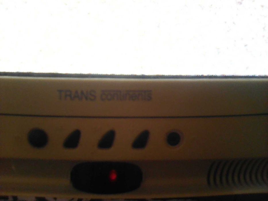 Televisão antiga a cores a funcionar, com comando e suporte de parede