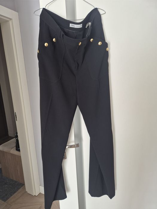 Czarne eleganckie spodnie damskie z szeroką nogawką i rzędowymi guzika