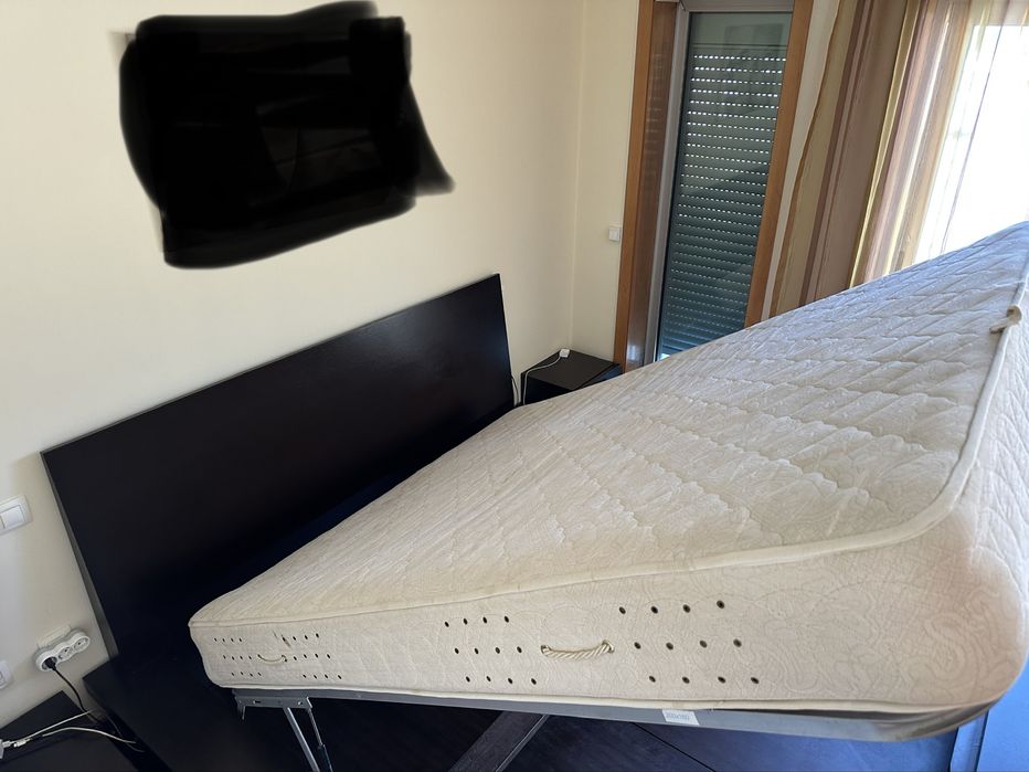 Cama casal grande com arrumação interior com blocos de apoio