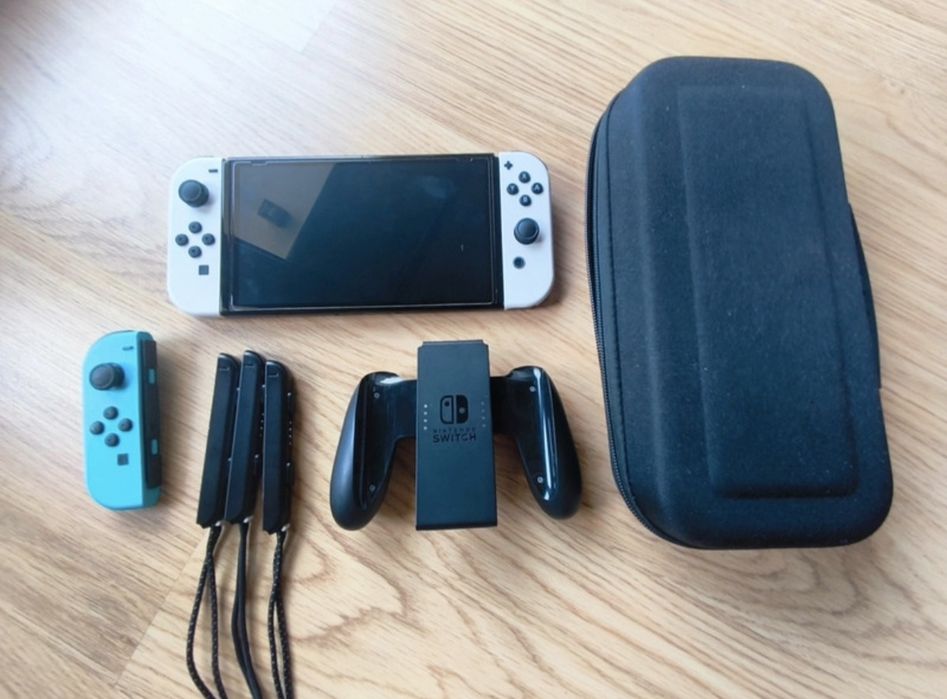 Consola Nintendo Switch OLED em excelente estado.

- Inclui Joy-Cons azuis e brancos.
- Base de carregamento e alças.
- Caixa de transporte preta.