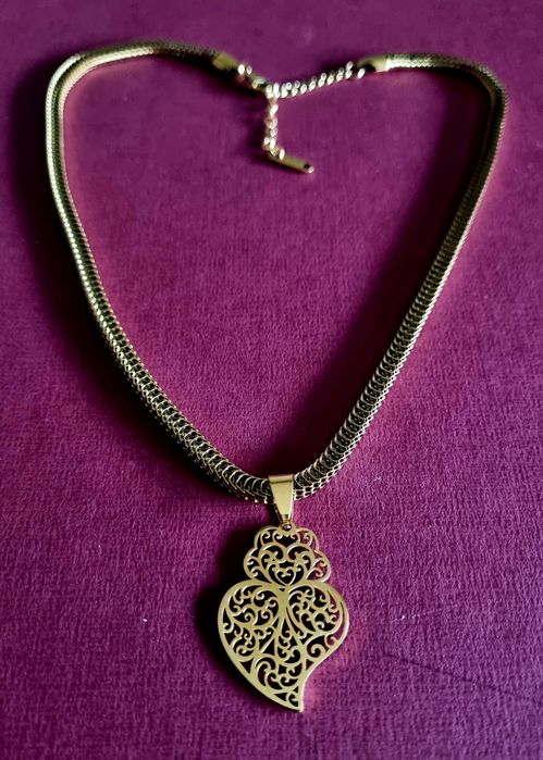 Colar dourado, em aço, malha grossa e um coração de Viana em filigrana