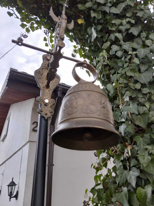 stary dzwon mosiężny , wiszący na stelażu