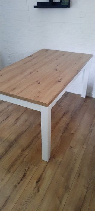 Ładny duży stół z drewnianym blatem i białymi nogami