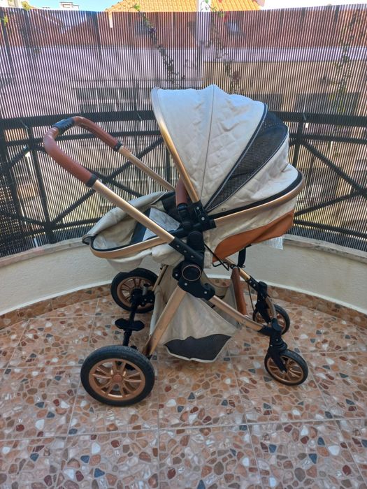 Carrinho de bebé com mmarcas de uso no puxador.