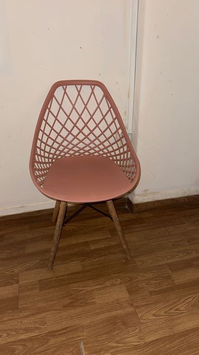 Cadeira de plástico rosa com pés de madeira