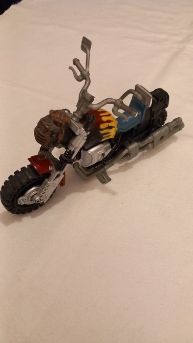 Mota de brinquedo que se assemelha a modelos como a G.I. Joe Dreadnok Cycle ou a Chap Mei Bad Guyz Cycle.