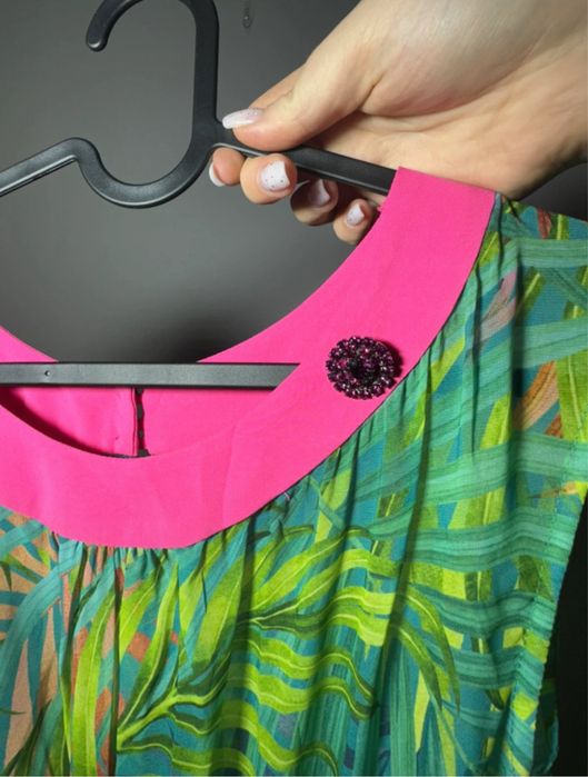 Zielona sukienka we wzorek z różowym paskiem przy szyji