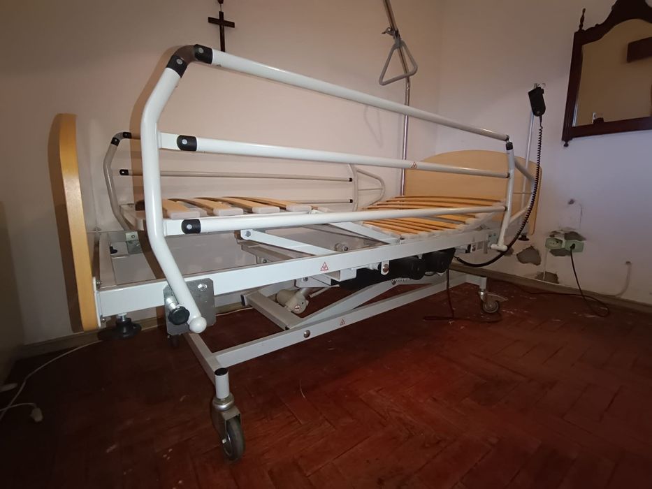 Cama articulada hospitalar com colchão, cadeira de rodas e muletas