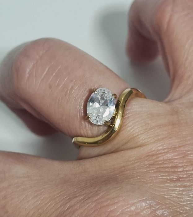 Anel dourado, em aço, muito diferente e com um ponto de luz oval. Ajustável