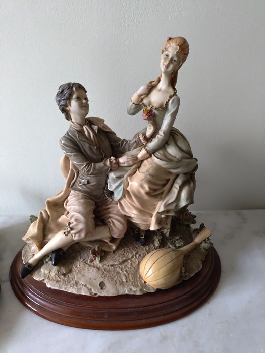 Estátua de dois amantes em base de madeira