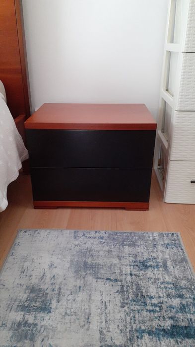 Cama de casal com uma mesa de cabeceira e colchão incluído