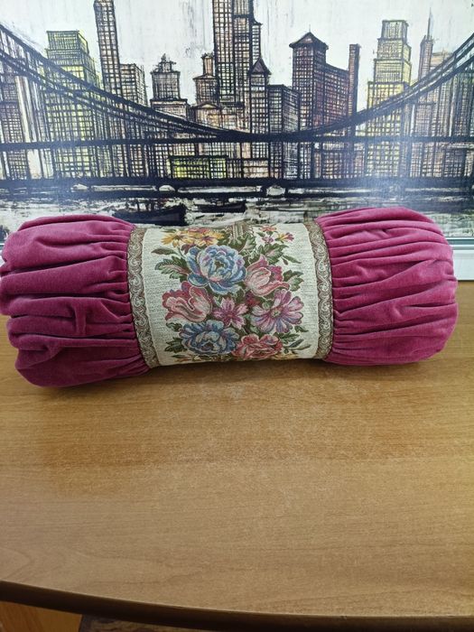 Elegancka poduszka dekoracyjna w kształcie wałka.