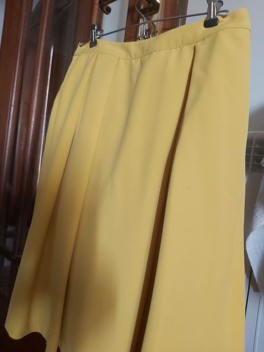 Saia encorpada, rodada em amarelo torrado.