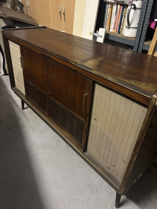 Movel rádio-giradiscos vintage dos anos 60 em madeira escura com grelha de coluna em tecido bege