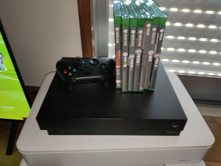 Xbox One X com jogos e headphone