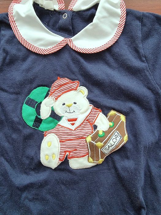 Romper azul com detalhe na gola e um urso 100% algodão, recém-nascido