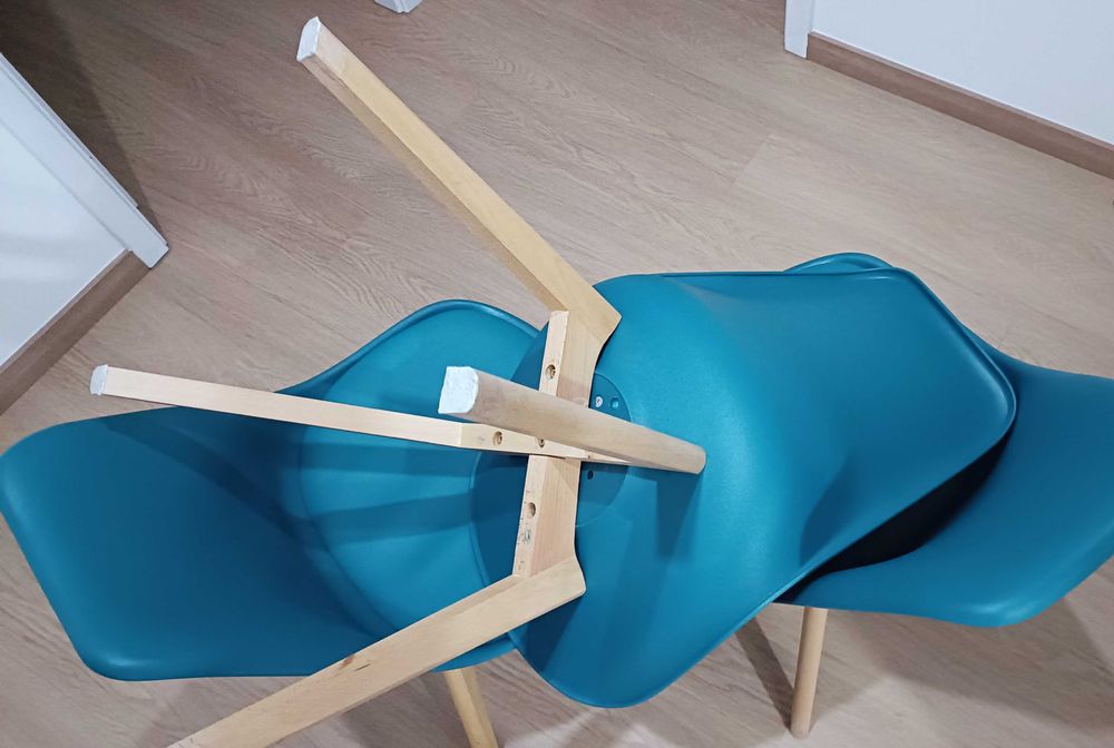 Cadeiras azul petróleo com penas em madeira