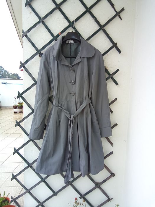 Gabardina cinza toda forrada
Aperta com botões e com molas
Tem cinto