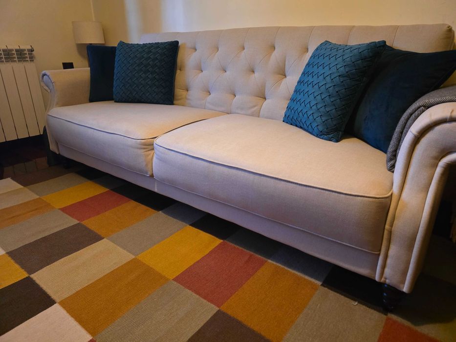 Sofá cama, tapete e almofadas decorativas
