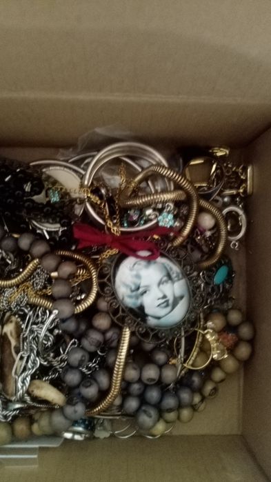 Caixa com jóias, colares, anéis, pulseiras, pingentes de colares e bri