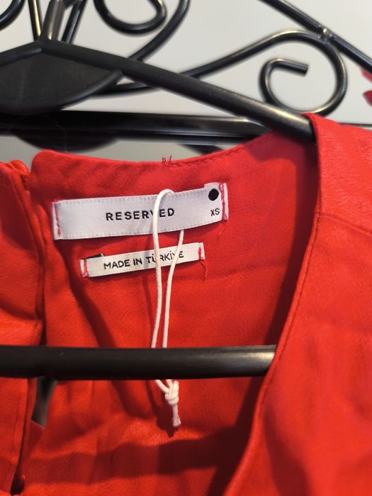 Czerwona sukienka z wyciętymi bokami.