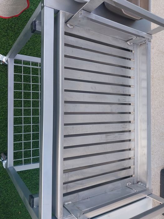 Churrasqueira com rodas, tem queimador  e grelha em inox  duas mesas de apoio uma em inox outra em nylon  e plataforma para lenha..