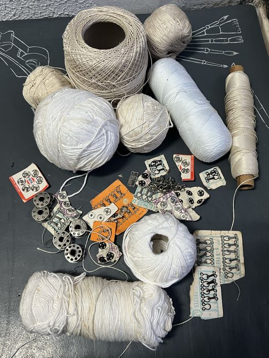 Retalhos de roupa nova, agulhas, novelos de renda
