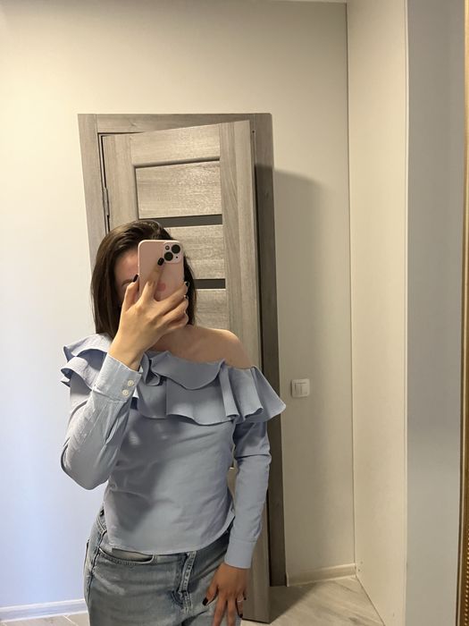 Блакитна блуза з оголеним плечем і обʼємним воланом