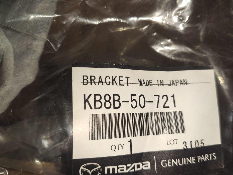 KB8B50721 Mazda кронштейн емблеми решітки радіатора
