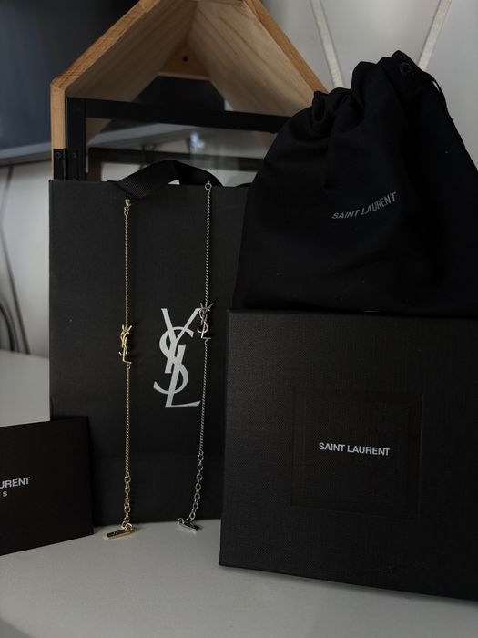 Sprzedam eleganckie bransoletki złote i srebne z ozdobną zawieszką YSL, w komplecie z całym zestawem Yves Saint Laurent.