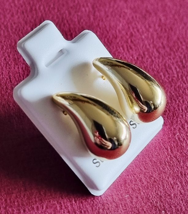 Pequenos brincos dourados, em aço, em forma de gota. De pico