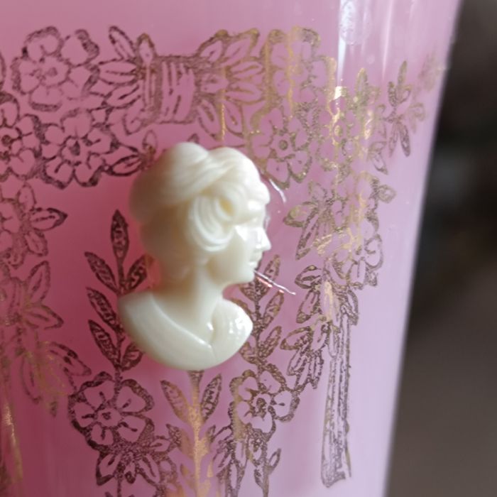 Uma imponente jarra rosa opalescente, com sua abertura rendada