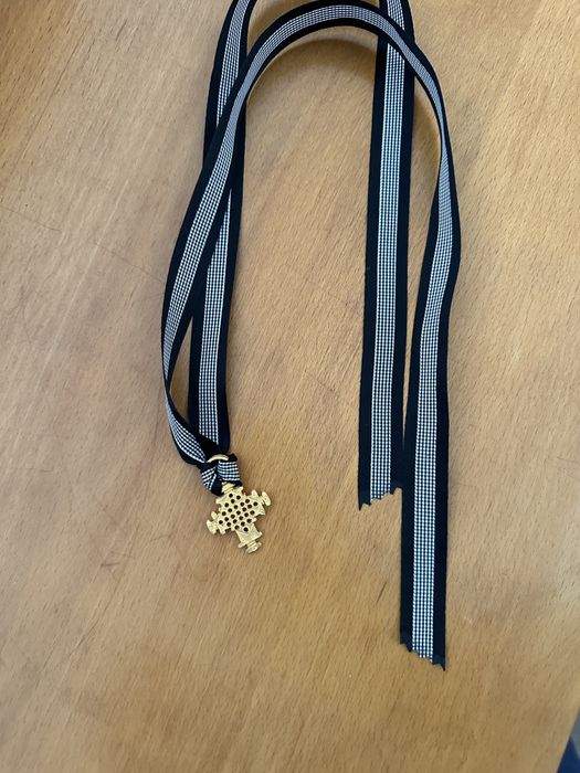 Cruz dourada com fita em seda