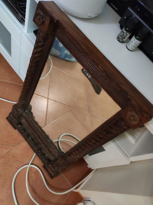 Espelho antigo com moldura em madeira.