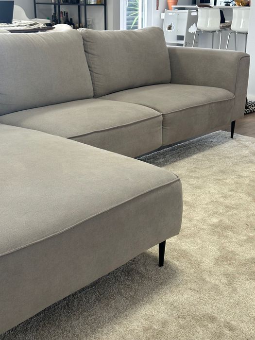 Sofá chaise long cinza com os pés pretos