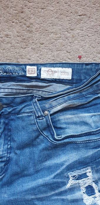 Spodnie jeansy z przetarciami.