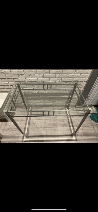 Szklany stół z metalowymi nogami