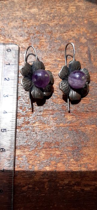 Brincos prateados em forma de flor com pedra roxa
