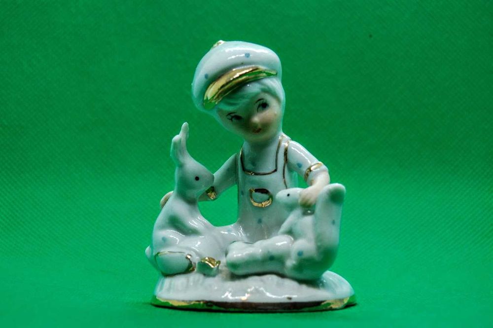 Estatueta antiga de menino em porcelana