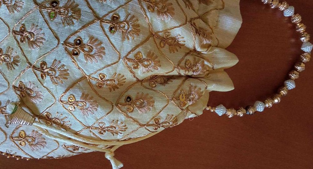 Bolsa de mão branca com bordado dourado