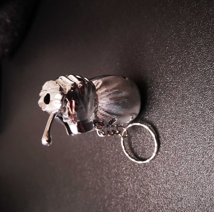 Isqueiro em forma de mão a segurar o saco do dinheiro