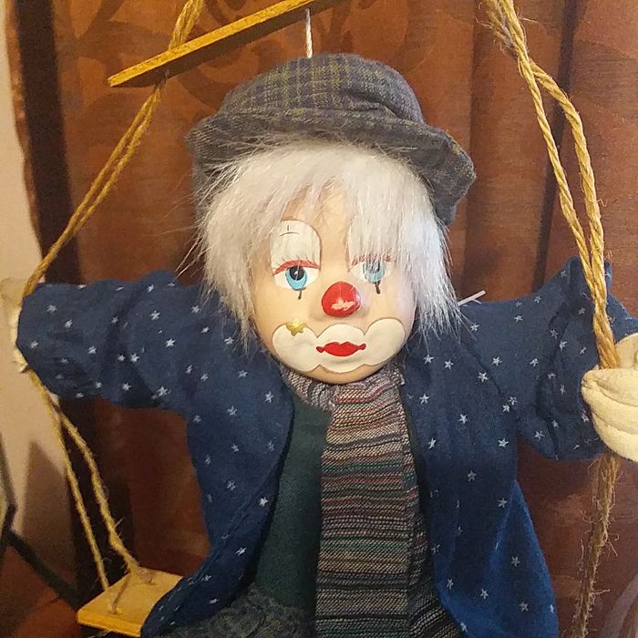 Игрушка клоун на качеле.