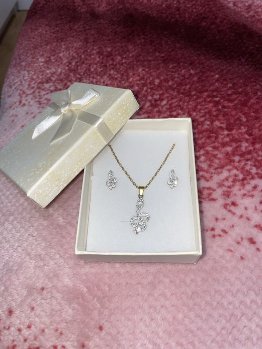 conjunto de colar e brincos dourados com simbolo de uma cobra