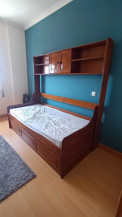 Estúdio em madeira, com estrados, colchões, gavetão e estante.