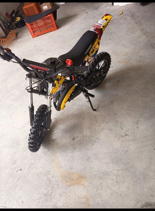 mini moto cross infantil com motor a gasolina de 49cc e gráficos de caveiras amarelas