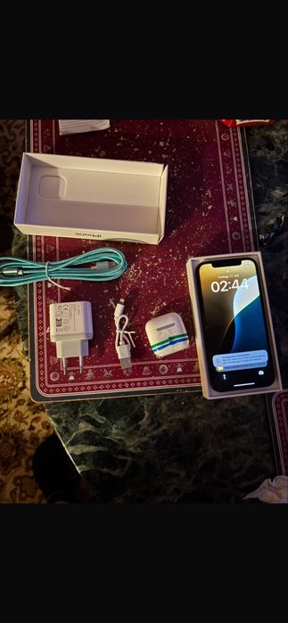 Iphone 12 z ladowarka i sluchawkami