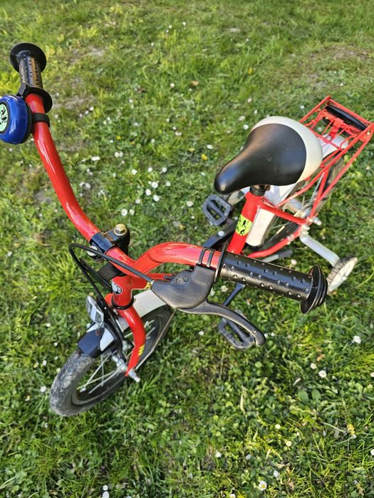 Rower czerwony z dostawionymi kółkami