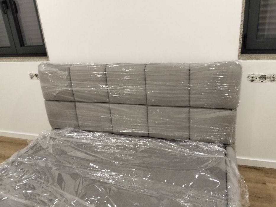 Cama em tecido nova com estrado elevatória incluída.